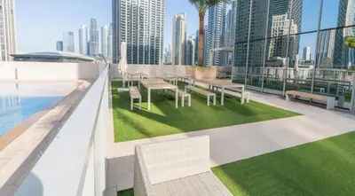 a rooftop patio with tables and chairs on a building at Exquisite 2BDR Retreat In Forte-33 in Dubai