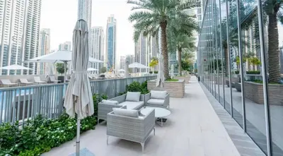 a balcony with chairs and a table and an umbrella at Exquisite 2BDR Retreat In Forte-33 in Dubai
