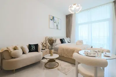 a bedroom with a bed and a couch and a table at Stylish Studio Apartment Skyz by Danube in Dubai