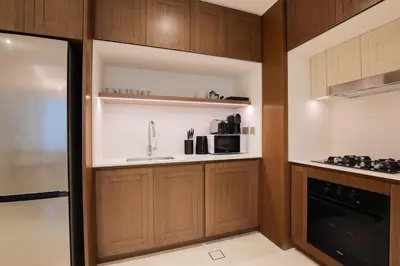 a kitchen with wooden cabinets and a sink at Lux 1BR Beachfront Living Palace Beach Residence in Dubai
