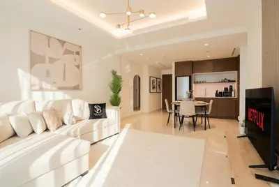 a living room with a white couch and a table at Lux 1BR Beachfront Living Palace Beach Residence in Dubai
