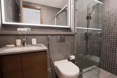 a bathroom with a shower and a toilet and a sink at Stylish & Chic 1BR - The Crest at Sobha Hartland in Dubai