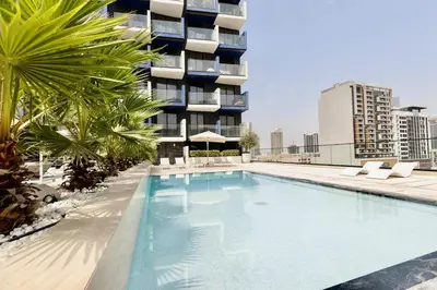 a swimming pool in front of a building at Prime 2BR in Binghatti Crest - JVC in Dubai