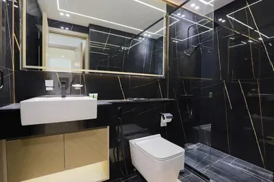 a bathroom with a toilet and a sink and a mirror at Prime 2BR in Binghatti Crest - JVC in Dubai