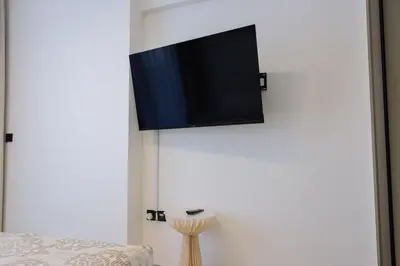 a flat screen tv hanging on a white wall at Prime 2BR in Binghatti Crest - JVC in Dubai