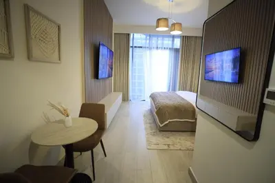a room with a table and a bedroom with a bed at Modern and cozy studio apartment in Dubai