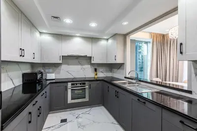 a kitchen with white cabinets and marble counter tops at Spacious 2 BDR apartment in Downtown Dubai I 29 Blvd in Dubai
