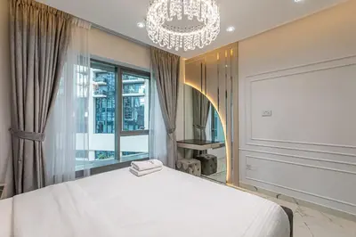a bedroom with a white bed and a chandelier at Spacious 2 BDR apartment in Downtown Dubai I 29 Blvd in Dubai