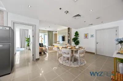 a kitchen and living room with a table and chairs at Salt & Sand Hamptons Glow 2BR Sulafa Tower in Dubai