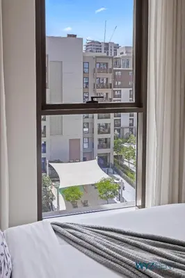 a bedroom with a window with a view of a building at Tranquil Boho 1BR in Surf 2 Creek Beach Access in Dubai