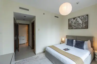 a bedroom with a large bed and a bathroom at Spacious - Stylish - Scenic Marina View in Dubai