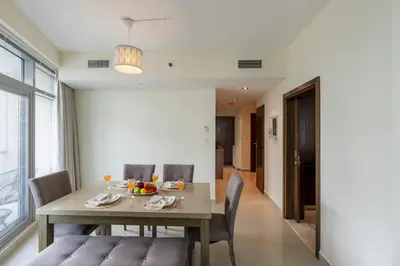a dining room with a wooden table and chairs at Spacious - Stylish - Scenic Marina View in Dubai