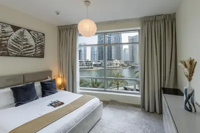 a bedroom with a bed and a large window at Spacious - Stylish - Scenic Marina View in Dubai