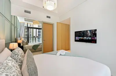 a bedroom with a bed and a tv on the wall at High Floor 2 Bedroom Apartment - Exclusive Luxury at Aykon Tower - PlayStation 5 in Dubai