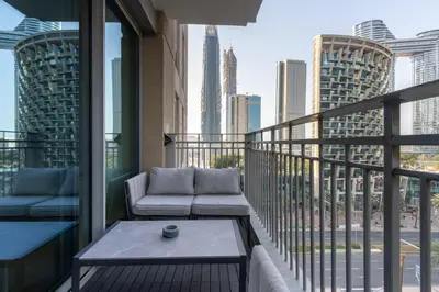 a balcony with a couch and a view of the city at Newly Upgraded 2BR - Steps from Burj Khalifa and Opera in Dubai