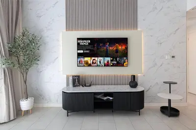 a living room with a tv on a wall at La Vie Seaside with Beach Access in Dubai