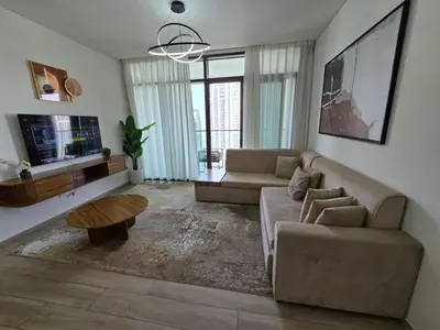 a living room with a couch and a table at Luxury 1BR with Scenic Views - Palace Residence in Dubai