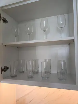 a row of wine glasses sitting on shelves at Luxury 1BR with Scenic Views - Palace Residence in Dubai