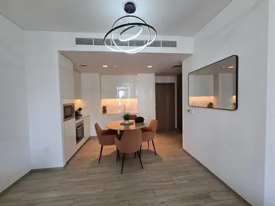 a kitchen and dining room with a table and chairs at Luxury 1BR with Scenic Views - Palace Residence in Dubai