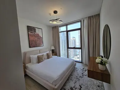 a bedroom with a white bed and a large window at Luxury 1BR with Scenic Views - Palace Residence in Dubai