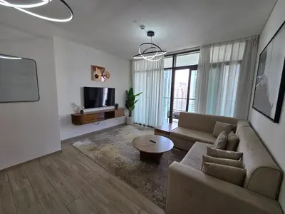 a living room with a couch and a table at Luxury 1BR with Scenic Views - Palace Residence in Dubai