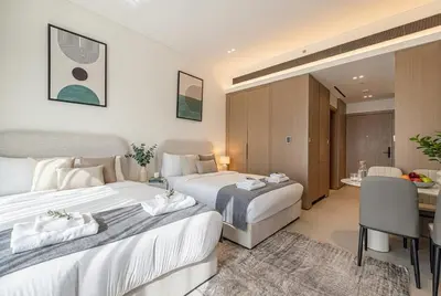 a hotel room with two beds and a desk at Binghatti Phoenix! Longest Pool in Dubai! Brand New Building, 2 Double Beds! in Dubai