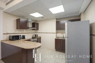 a kitchen with a counter top and a refrigerator at LUX The JLT Gold Crest Suite in Dubai