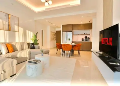 a living room with a couch and a tv and a table at Lux 2BR Beachfront Escape Palace Beach Residence in Dubai