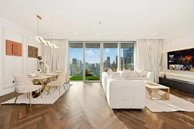 a living room with a white couch and a table at Ultra Luxury 4BR 7P Burj and Fountain View in Dubai