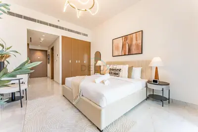 a bedroom with a large white bed and a table at Just Minutes Drive From Dubai Autodrome, Conveniently Located Within A Short Walk Of The Bus Stop, Azizi Vista, Dubai Studio City by Deluxe Holiday Homes in Dubai