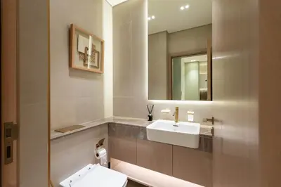 a bathroom with a white sink and a mirror at Luxury Apartment in JVC with Private Balcony Pool in Dubai