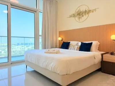 a bedroom with a large bed with a large window at Mahenti - Stunning Golf View Studio in Damac Hills in Dubai