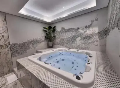 a bathroom with a bath tub with a painting on the wall at Luxury 2BR - Paramount Midtown with Infinity Pool in Dubai