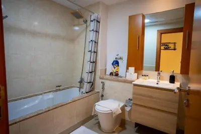 a bathroom with a tub and a toilet and a sink at Luxury 2BR Haven with Panoramic Scenery in Dubai
