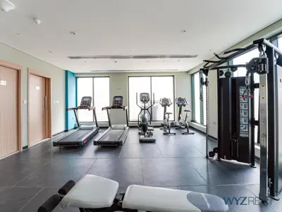 a gym with treadmills and machines in a room at Winter Wonderland Studio Azizi Riviera 9 Pool View in Dubai