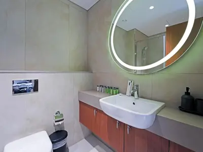 a bathroom with a sink and a mirror at Elegant Modern Studio- Peaceful Studio City in Dubai