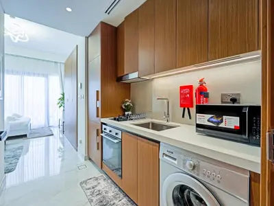 a kitchen with a washing machine and a sink at Elegant Modern Studio- Peaceful Studio City in Dubai