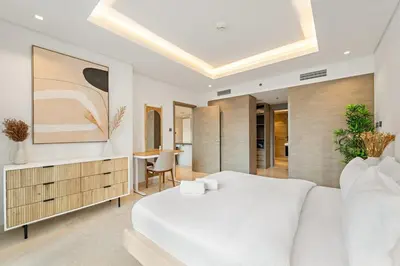 a bedroom with a large white bed and a table at FIRST CLASS 1BR Burj Views , Prime Location in Dubai