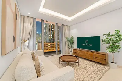 a living room with a couch and a tv at FIRST CLASS 1BR Burj Views , Prime Location in Dubai