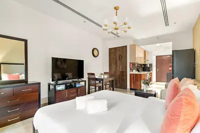 a living room with a bed and a dining room at FIRST CLASS Studio Iconic Burj Khalifa View in Dubai