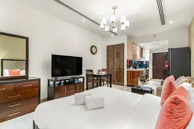 a living room with a white table and a television at FIRST CLASS Studio Iconic Burj Khalifa View in Dubai