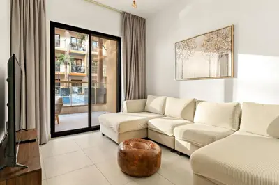 a living room with a couch and a table at FIRST CLASS 1BR Tranquil Pool View Retreat in Dubai