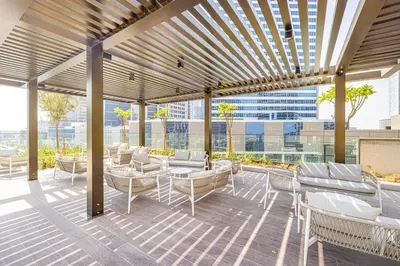 a patio with couches and tables on a building at Lux 1BR with Stunning Canal Views in Dubai