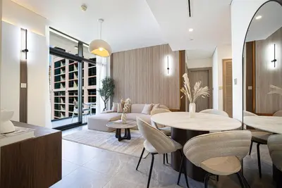 a living room with a table and chairs at Lux 1BR with Stunning Canal Views in Dubai