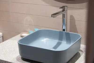 a blue sink sitting on a counter in a bathroom at Lux 1BR with Stunning Canal Views in Dubai