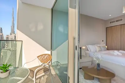 a hotel room with a bed and a glass door at Upscale Studio with Peninsula Lifestyle in Dubai