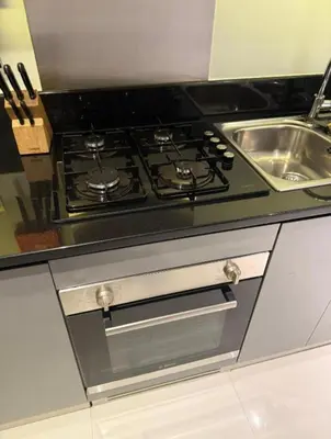 a stove top oven in a kitchen next to a sink at Exquisite Studio - Damac Prive with balcony & canal view in Dubai