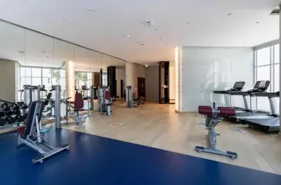 a gym with treadmills and cardio equipment in a room at Exquisite Studio - Damac Prive with balcony & canal view in Dubai