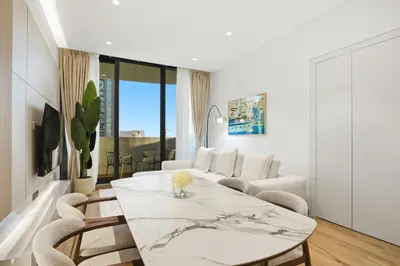 a white living room with a table and chairs at Chic 2Bedroom with Exceptional Facilities in JVC in Dubai