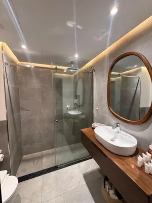 a bathroom with a shower and a sink and a mirror at Modern 1BR Marina 3mins walk to JBR Beach & Tram in Dubai